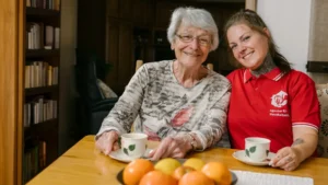 Agentur für Haushaltshilfe - Seniorin und Haushaltshelferin am Esstisch